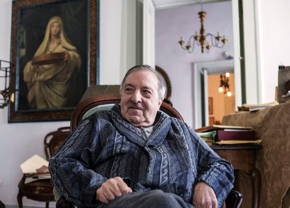 Roberto De Simone. Una notizia arrivata come un colpo secco, improvviso, dritto al cuore. Un addio che sa di rimorso e di consapevolezza tardiva. Perché con De Simone non se ne va soltanto un intellettuale, un musicologo, un regista, un compositore, un antropologo. Con lui si spegne una voce unica e irripetibile, quella che custodiva — come pochi altri — il mistero profondo dell’identità napoletana.